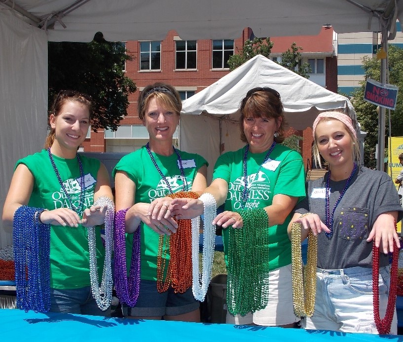 Four women holding honor beads on their arms at the Overnight Walk