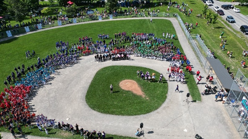 A group of people standing on a baseball fieldDescription automatically generated