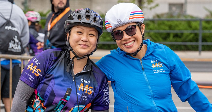 Two people with bike helmets on smiling