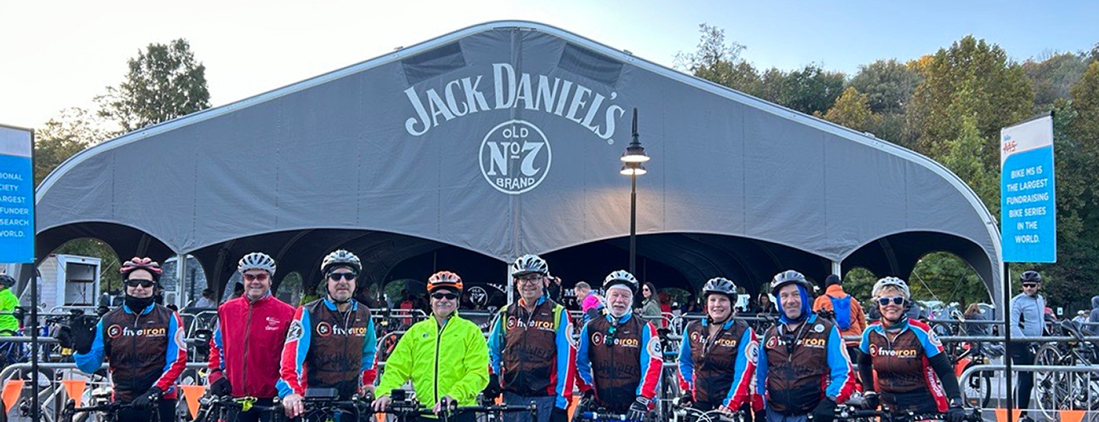 People standing with bikes in front of a tent that reads 'Jack Daniel's'