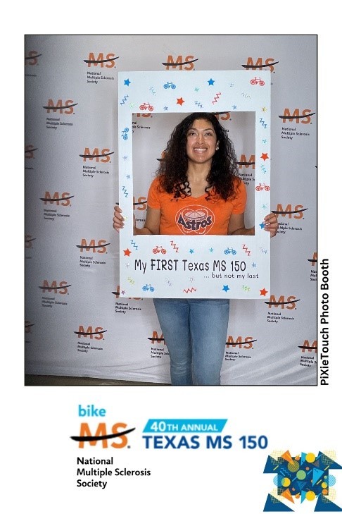 Woman wearing orange poses in Bike MS Photobooth