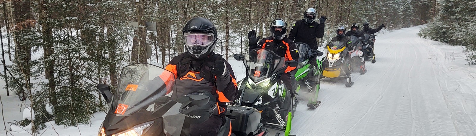 Line of 6 riders on their snowmobiles