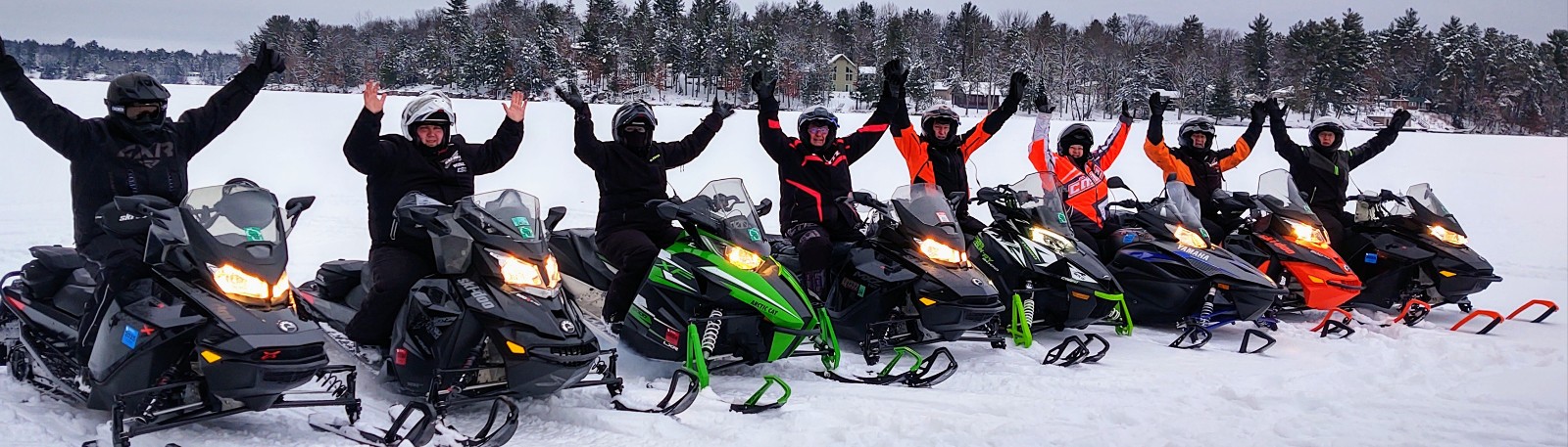 Snowmobile team cheering with their hands in the air